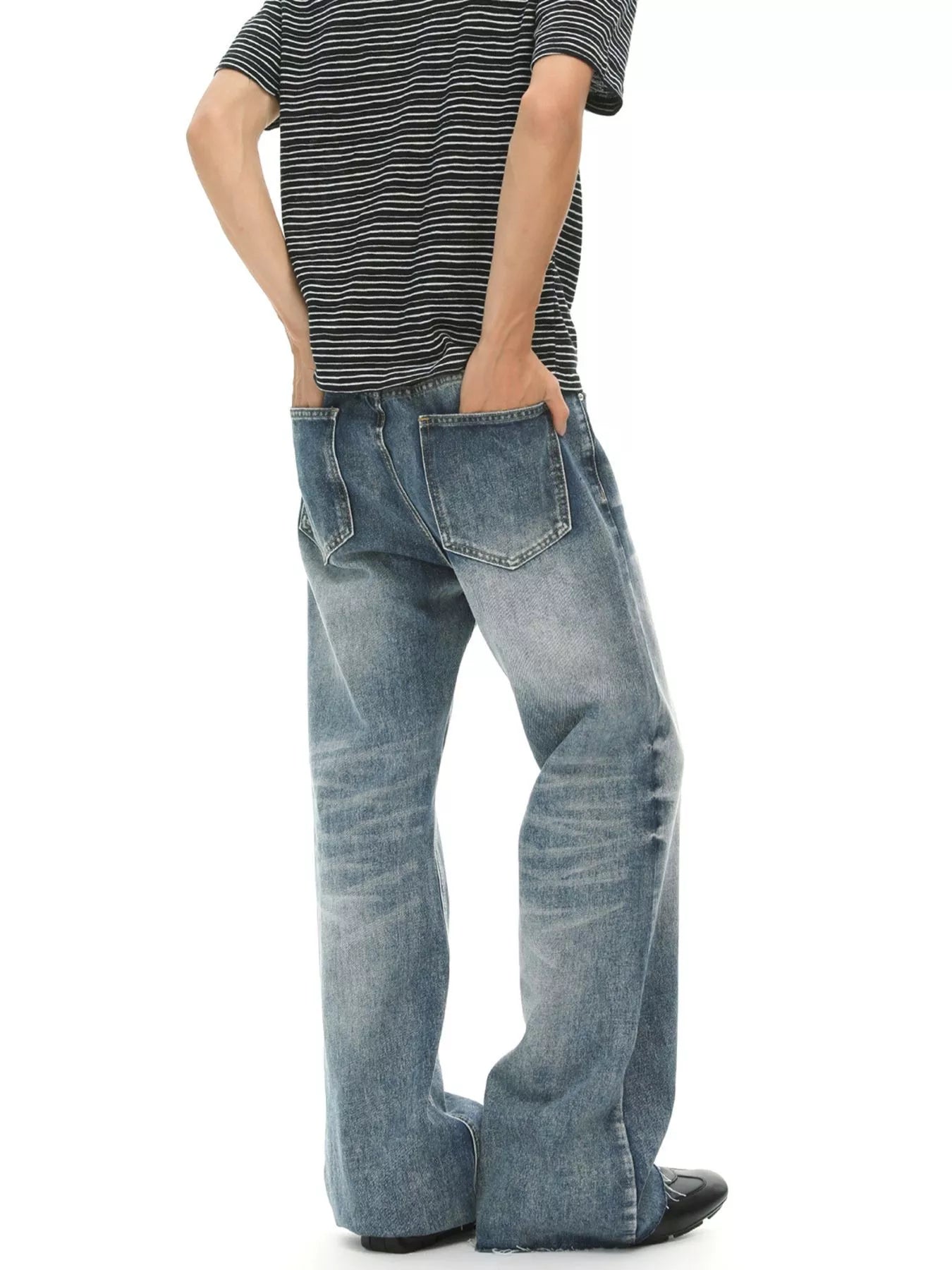 Men's vintage wash flare jeans with raw hem and pockets from Trendsi, featuring a classic distressed denim look.